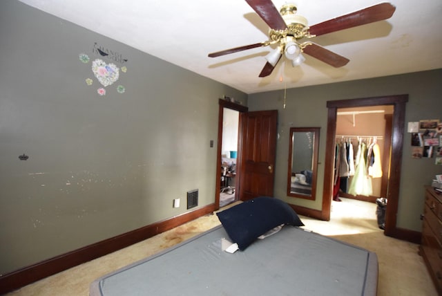 carpeted bedroom featuring baseboards, visible vents, a ceiling fan, a walk in closet, and a closet