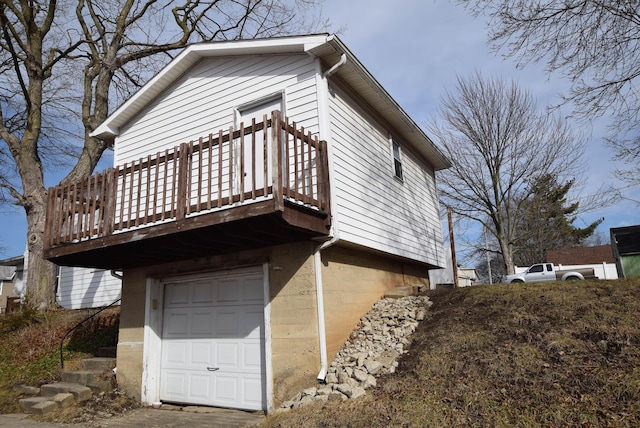 view of property exterior with an attached garage and a wooden deck