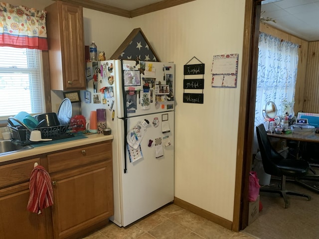 kitchen with ornamental molding and white fridge