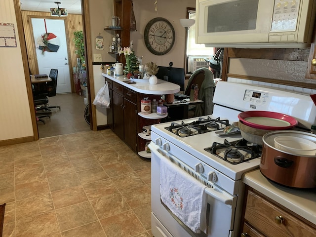 kitchen featuring white appliances and dark brown cabinetry