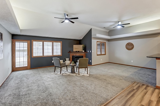 dining space with a fireplace, carpet flooring, a ceiling fan, and baseboards