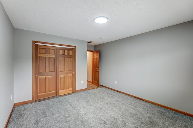 unfurnished bedroom featuring carpet, visible vents, baseboards, and a closet