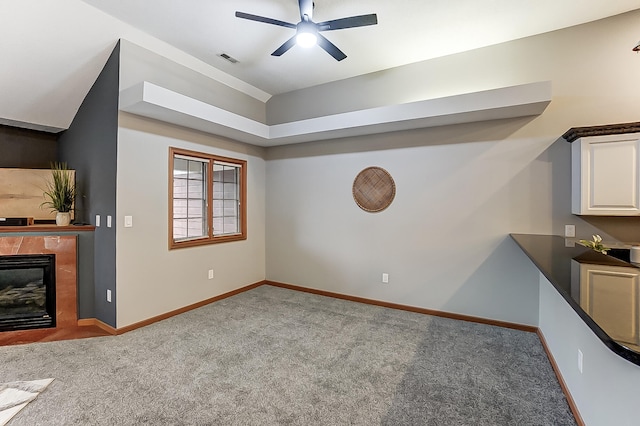 carpeted living room featuring a glass covered fireplace, visible vents, ceiling fan, and baseboards