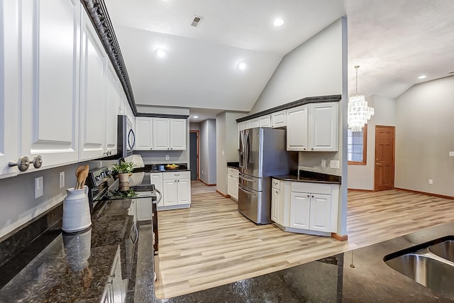 kitchen with lofted ceiling, stainless steel appliances, visible vents, white cabinetry, and light wood finished floors