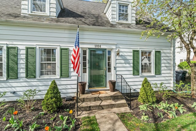 entrance to property with roof with shingles