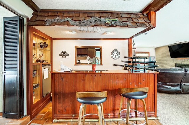 bar featuring carpet flooring, a textured ceiling, and a dry bar