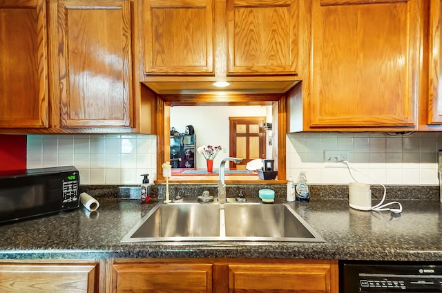 kitchen featuring black appliances, backsplash, a sink, and brown cabinets