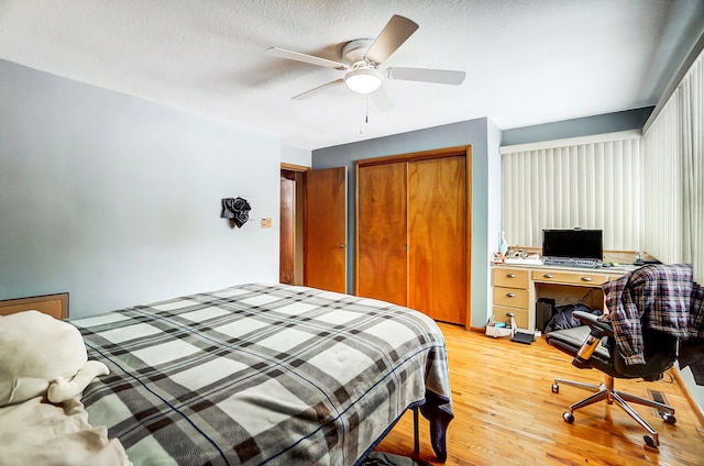 bedroom with light wood-type flooring, a closet, ceiling fan, and a textured ceiling