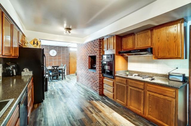 kitchen with black appliances, under cabinet range hood, brown cabinets, and dark wood-style flooring