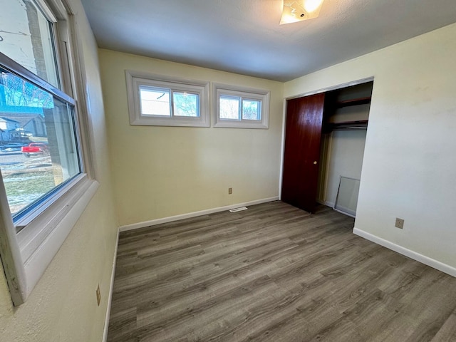 unfurnished bedroom featuring dark hardwood / wood-style flooring and a closet