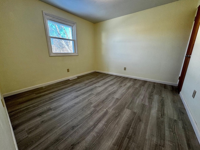 unfurnished room featuring dark wood-type flooring