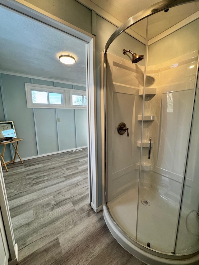 bathroom with wood-type flooring and walk in shower