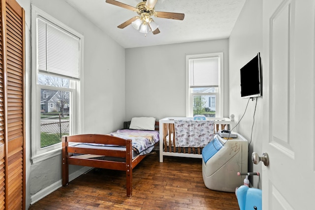 bedroom with ceiling fan, hardwood / wood-style flooring, and baseboards