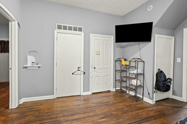 bedroom featuring visible vents, baseboards, hardwood / wood-style floors, and a textured ceiling