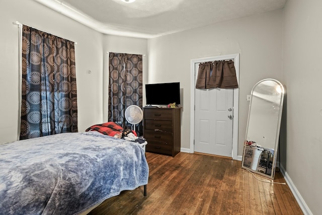bedroom featuring baseboards and hardwood / wood-style flooring