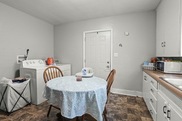 dining area with washer and clothes dryer, baseboards, and stone finish flooring