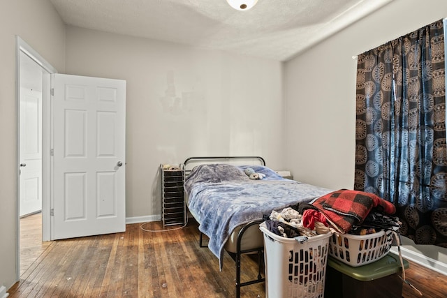 bedroom featuring hardwood / wood-style floors and baseboards