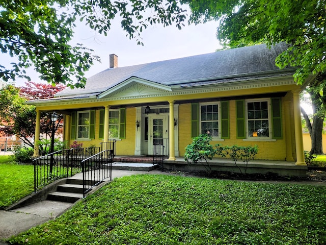 120 N Perry St, Saint Marys, OH 45885 - view of front facade with covered porch, a shingled roof, a front lawn, and brick siding