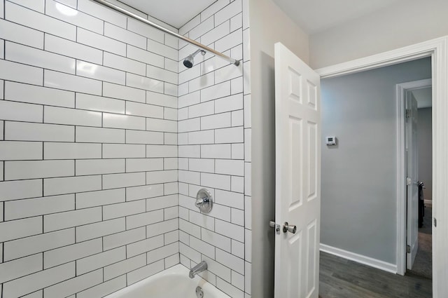 bathroom featuring shower / bath combination, baseboards, and wood finished floors