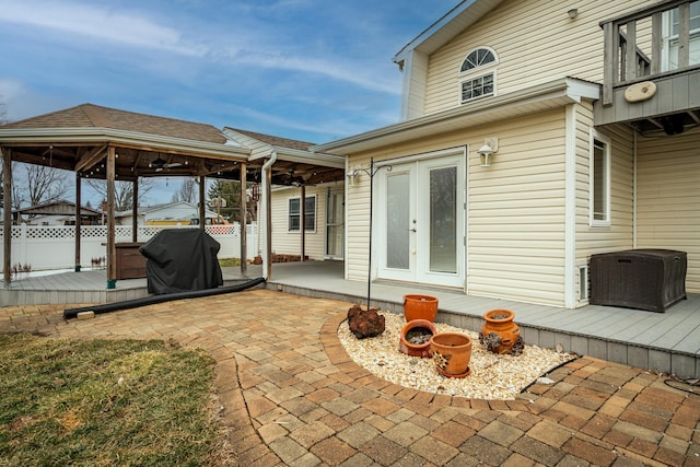 exterior space featuring a hot tub, a wooden deck, fence, and french doors