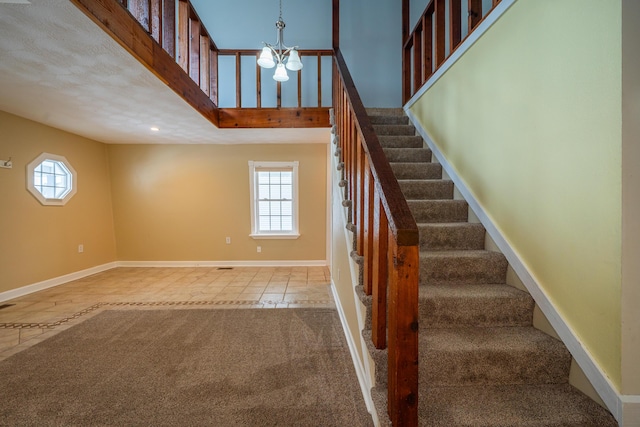 stairs featuring carpet floors, a towering ceiling, baseboards, and a wealth of natural light