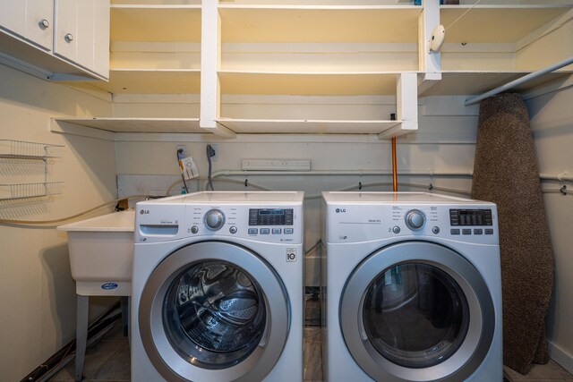 clothes washing area with cabinet space and separate washer and dryer