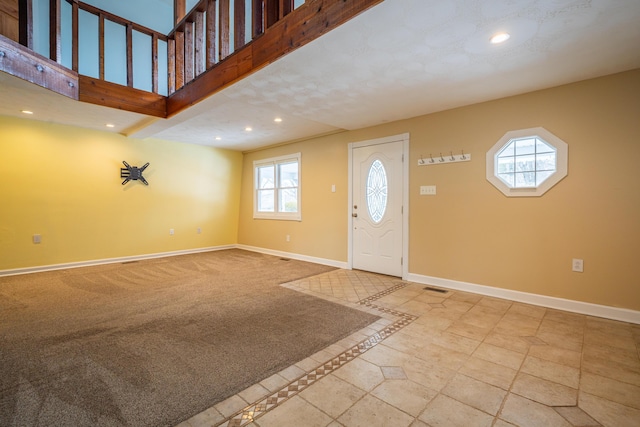 foyer entrance with recessed lighting, a towering ceiling, and baseboards