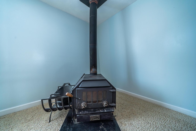 room details featuring carpet, a wood stove, and baseboards