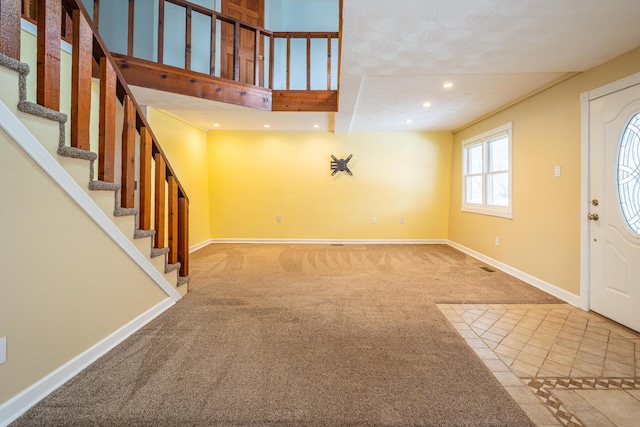 carpeted entrance foyer featuring recessed lighting, stairway, and baseboards