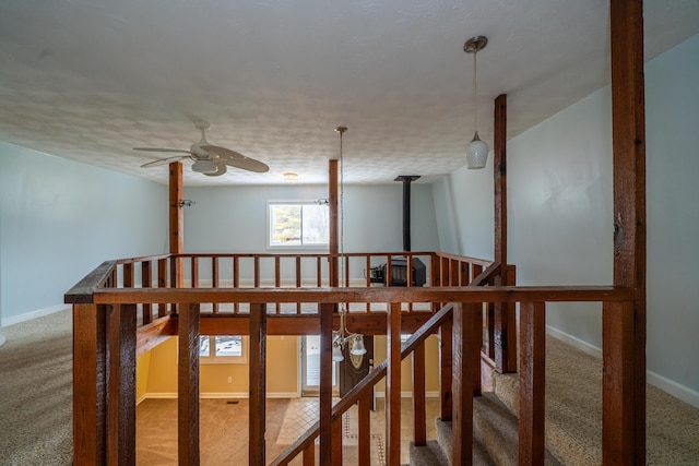 stairway featuring ceiling fan, carpet flooring, and baseboards