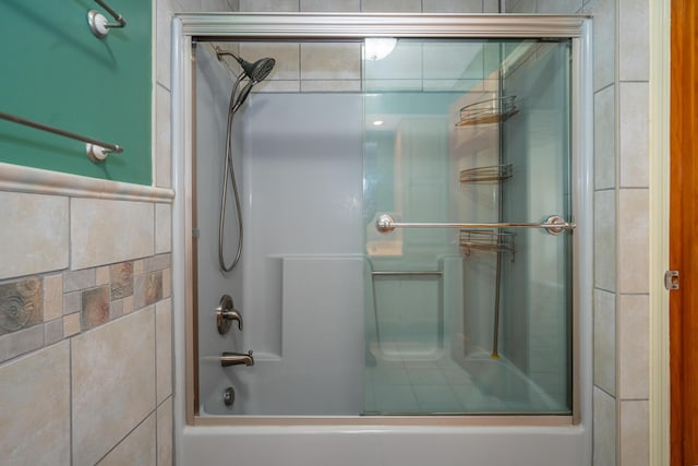 full bath with enclosed tub / shower combo and tile walls