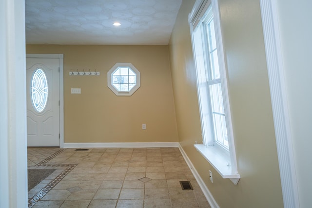 entryway featuring light tile patterned floors, baseboards, and visible vents