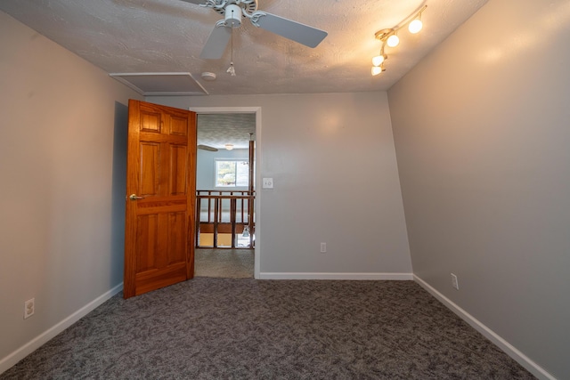 carpeted empty room featuring a textured ceiling, ceiling fan, and baseboards