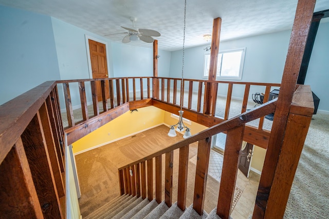 staircase with carpet, baseboards, and a textured ceiling