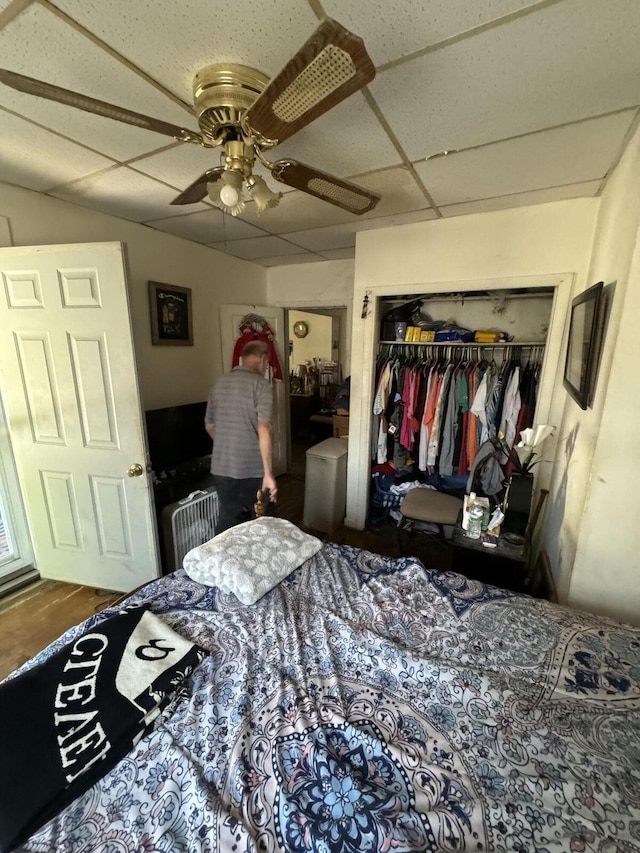 bedroom with a paneled ceiling, ceiling fan, and a closet