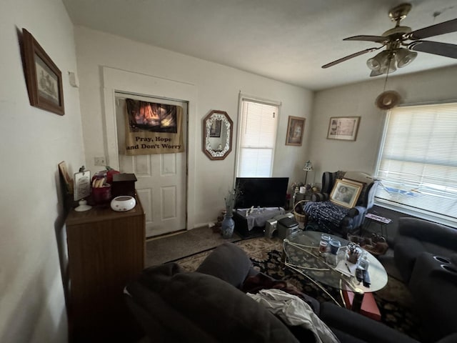 living area featuring ceiling fan and carpet flooring