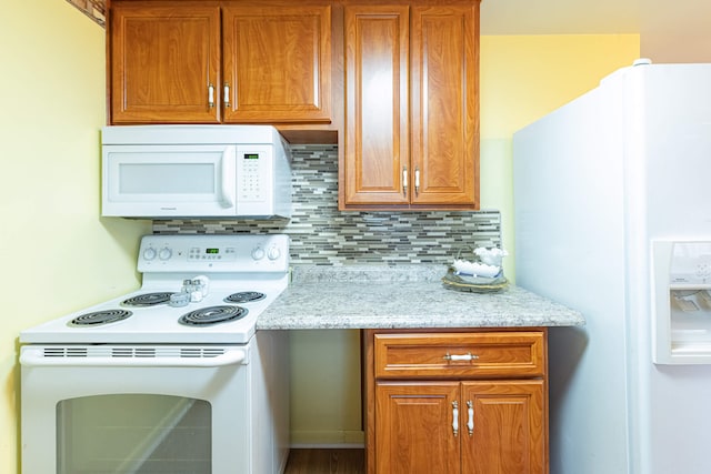 4833 Mesa Ln, Springfield, OH 45503 - kitchen featuring white appliances, decorative backsplash, brown cabinetry, and light stone counters