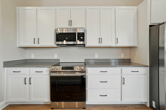 1505 Kingsgate Rd, Springfield, OH 45503 - kitchen with stainless steel appliances, white cabinets, and light wood-type flooring