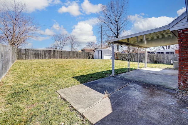 view of yard featuring a storage unit, an outbuilding, a fenced backyard, and a patio area