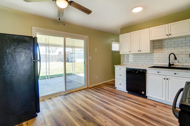 kitchen with black appliances, a sink, backsplash, white cabinets, and light wood finished floors