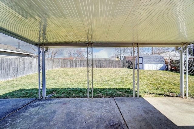 view of patio / terrace with a storage unit, an outbuilding, and a fenced backyard