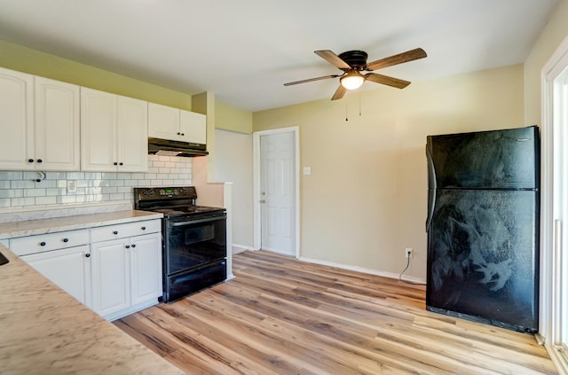 kitchen with black appliances, light countertops, light wood-style floors, under cabinet range hood, and tasteful backsplash