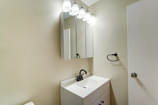 half bath with a chandelier and vanity