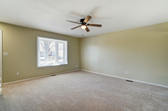 carpeted empty room featuring visible vents, baseboards, and a ceiling fan