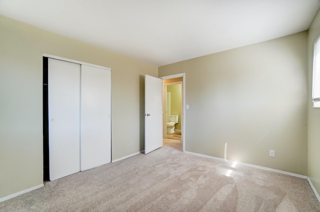 unfurnished bedroom with a closet, baseboards, and carpet floors