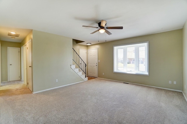 unfurnished living room featuring stairway, visible vents, light colored carpet, and baseboards