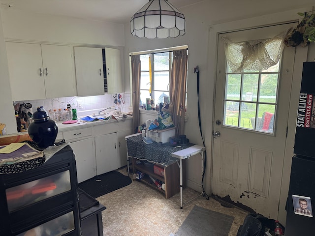 914 Mitchell Blvd, Springfield, OH 45503 - kitchen with healthy amount of natural light, white cabinetry, light countertops, and decorative backsplash