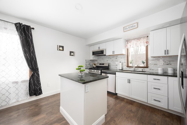 kitchen featuring a kitchen island, appliances with stainless steel finishes, white cabinetry, sink, and dark wood-type flooring