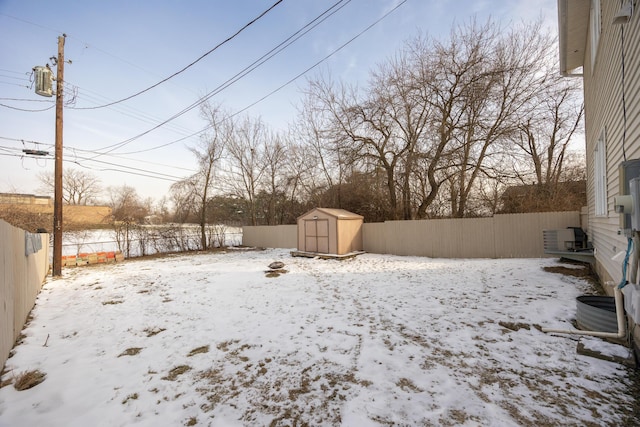 yard layered in snow with a storage shed