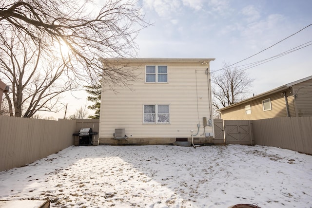 snow covered back of property with central AC unit